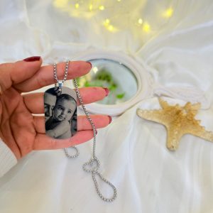 پلاک بیضی نقره‌ای با حک چهره و زنجیر استیل کارتیر.